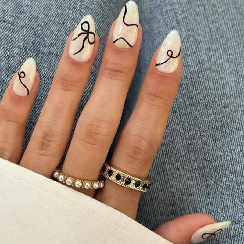 StarNagel Almond Nägel in Weiß und Schwarz mit Streifen und Schleifen