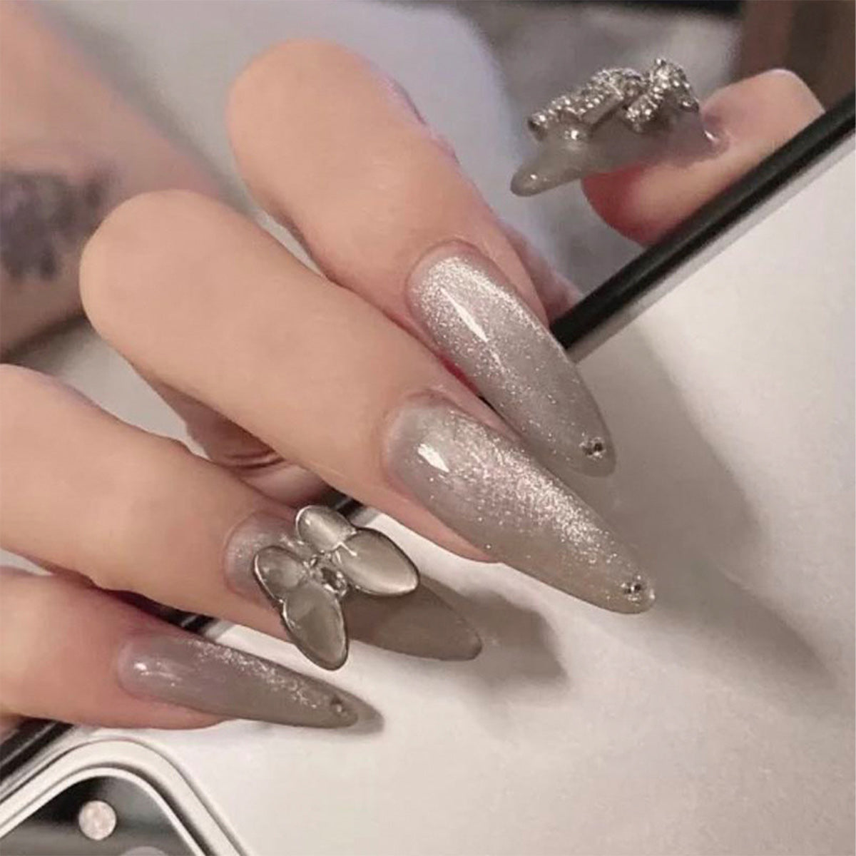 StarNagel Stiletto Nägel mit silbernem Glitzer und metallischem Schleifen-Design
